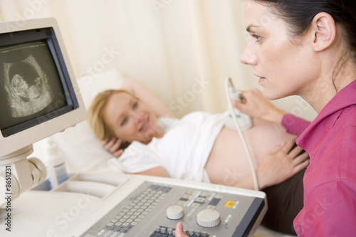 Photo: Pregnant woman getting ultrasound from doctor Pregnant woman getting ultrasound from doctor