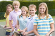 Foto: Five young friends with rackets on tennis court smiling Five young friends with rackets on tennis court smiling