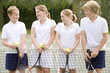 Foto: Four young friends with rackets on tennis court smiling Four young friends with rackets on tennis court smiling