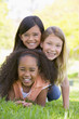 Photo: Three young girl friends piled up on top of each other outdoors Three young girl friends piled up on top of each other outdoors
