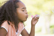 Photo: Young girl blowing bubbles outdoors Young girl blowing bubbles outdoors
