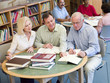 Mature students studying together in library
