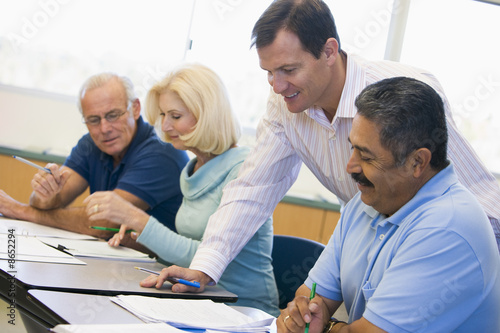 Foto: Teacher assisting mature student in class Teacher assisting mature student in class