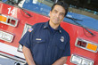 Portrait of a firefighter by a fire engine