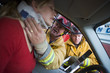 Firefighters helping an injured woman in a car