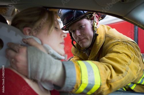 Photo: Firefighters helping an injured woman in a car Firefighters helping an injured woman in a car