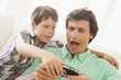 Photo: Young boy taking handheld game from unhappy man Young boy taking handheld game from unhappy man