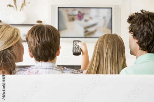 Family in living room with remote control and flat screen televi