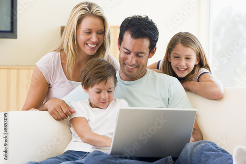 Photo: Family in living room with laptop smiling Family in living room with laptop smiling