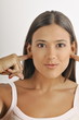 "Female young adult;plugging ears with fingers"