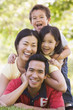 Family lying outdoors smiling