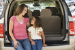 Photo: Woman with young girl sitting in back of van smiling Woman with young girl sitting in back of van smiling