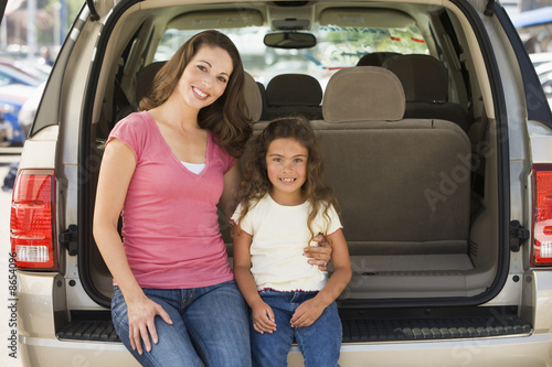Photo: Woman with young girl sitting in back of van smiling Woman with young girl sitting in back of van smiling
