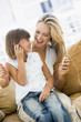 Woman and young girl in living room with MP3 player smiling Woman and young girl in living room with MP3 player smiling