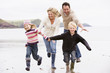 Photo: Family running on beach holding hands smiling Family running on beach holding hands smiling