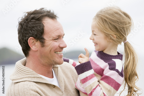 Photo: Father and daughter at beach smiling Father and daughter at beach smiling