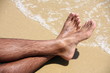 Man's bare feet on sand