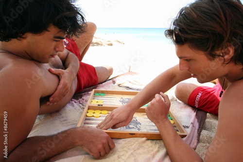 Photo: Two men on beach playing backgammon Two men on beach playing backgammon
