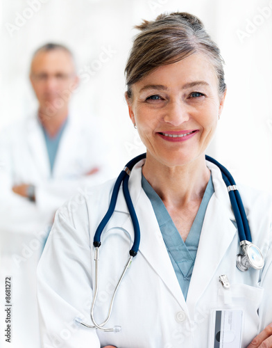 Smiling female doctor with colleague in background