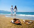 Young attractive couple at the beach holding hands focused front