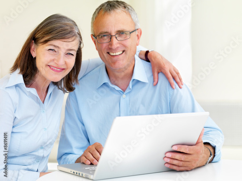 Happy old couple using laptop