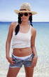 Young woman in hat;tank;and jean shorts on beach