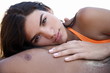 Young woman on man's chest on beach