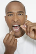 Man flossing teeth, portrait