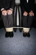 Male and female business people's legs tied