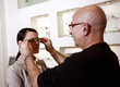 Woman having glasses fitted by optometrist