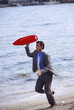 Businessman on beach with life preserver