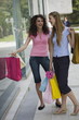 Two women with shopping bags looking at shop window