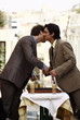 Businessmen shaking hands and kissing on cheek