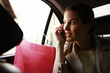 Woman on the cell phone with shopping bags in a taxi