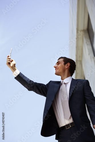 Foto: Businessman holding cell phone to get a signal *** Local Caption *** Young executives doing business in an outdoor restaurant, by the park and on the move. Businessman holding cell phone to get a signal *** Local Caption *** Young executives doing business in an outdoor restaurant, by the park and on the move.