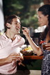 Woman feeding man in a bar