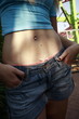Closeup of female teenager's pierced belly button at amusement park