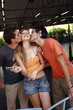 Two male teenagers kissing female teenager
