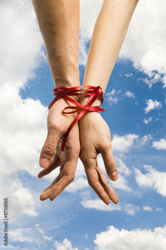 Photo: hands tieing with ribbon hands tieing with ribbon