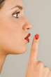 "Female young adult;finger to lips"