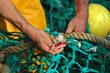 pêcheur réparant un filet de pêche