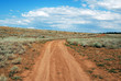 Twisting rural soil road passing through hills