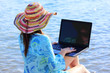 girl using a laptop near the sea