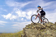 Girl rides a bike in mountains.