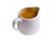Sweet caramel sauce in white sauce-boat on white ground