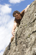 Photo: Man climbing on steep rocks, reaching for the top Man climbing on steep rocks, reaching for the top