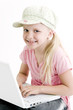 Young girl using a laptop computer over white background