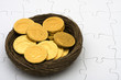 Brown nest with gold coins inside on puzzle, retirement nest egg Brown nest with gold coins inside on puzzle, retirement nest egg