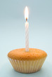 Plain cupcake with single white candle emphasising simplicity
