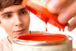 Young man opening red paint can